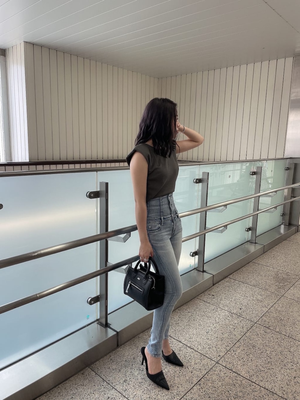 グレー系のTシャツ/カットソー、ブラック系のハンドバッグ、ブラック系のパンプスを着用したレディースの夏コーディネートの2枚目の写真