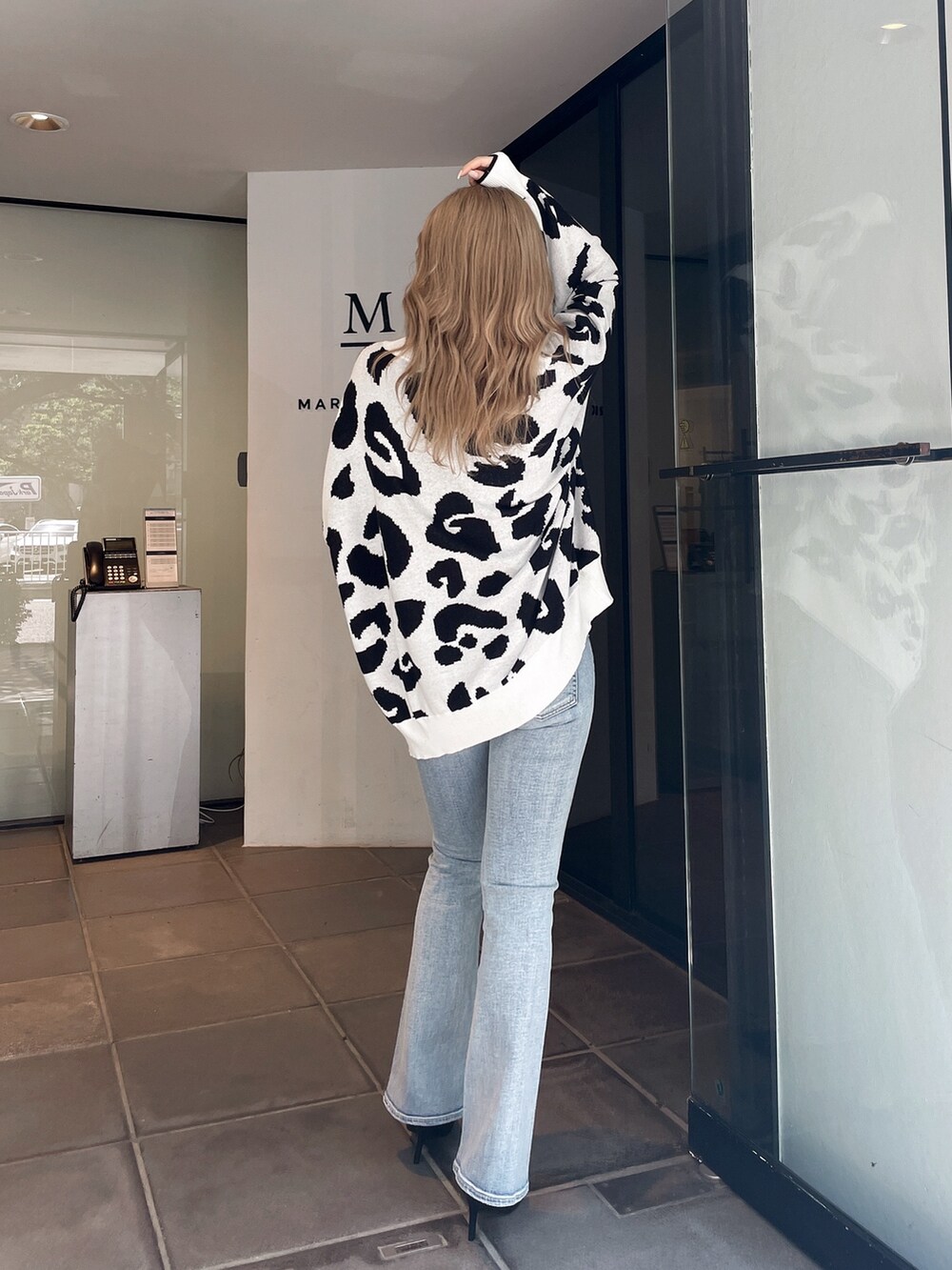 ホワイト系のカーディガン/ボレロ、ブルー系のデニムパンツ、ブラック系のパンプスを着用したレディースの夏コーディネートの3枚目の写真