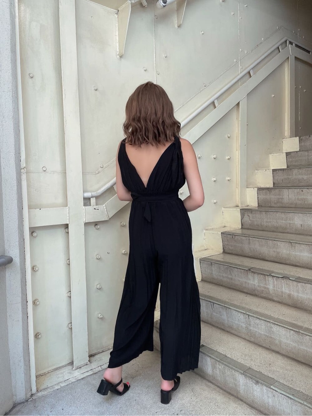 ブラック系のつなぎ/オールインワン、ブラック系のサンダル、ホワイト系のハンドバッグを着用したレディースの夏コーディネートの4枚目の写真