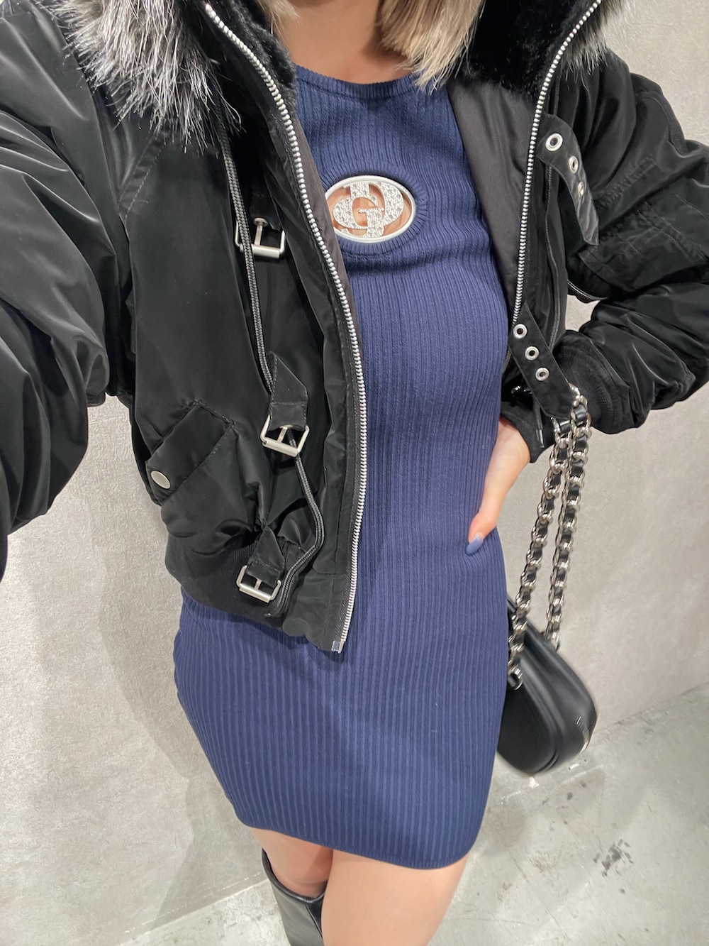 ブラック系のブルゾン、ブルー系のワンピース、ブラック系のショルダーバッグを着用したレディースの冬コーディネートの2枚目の写真