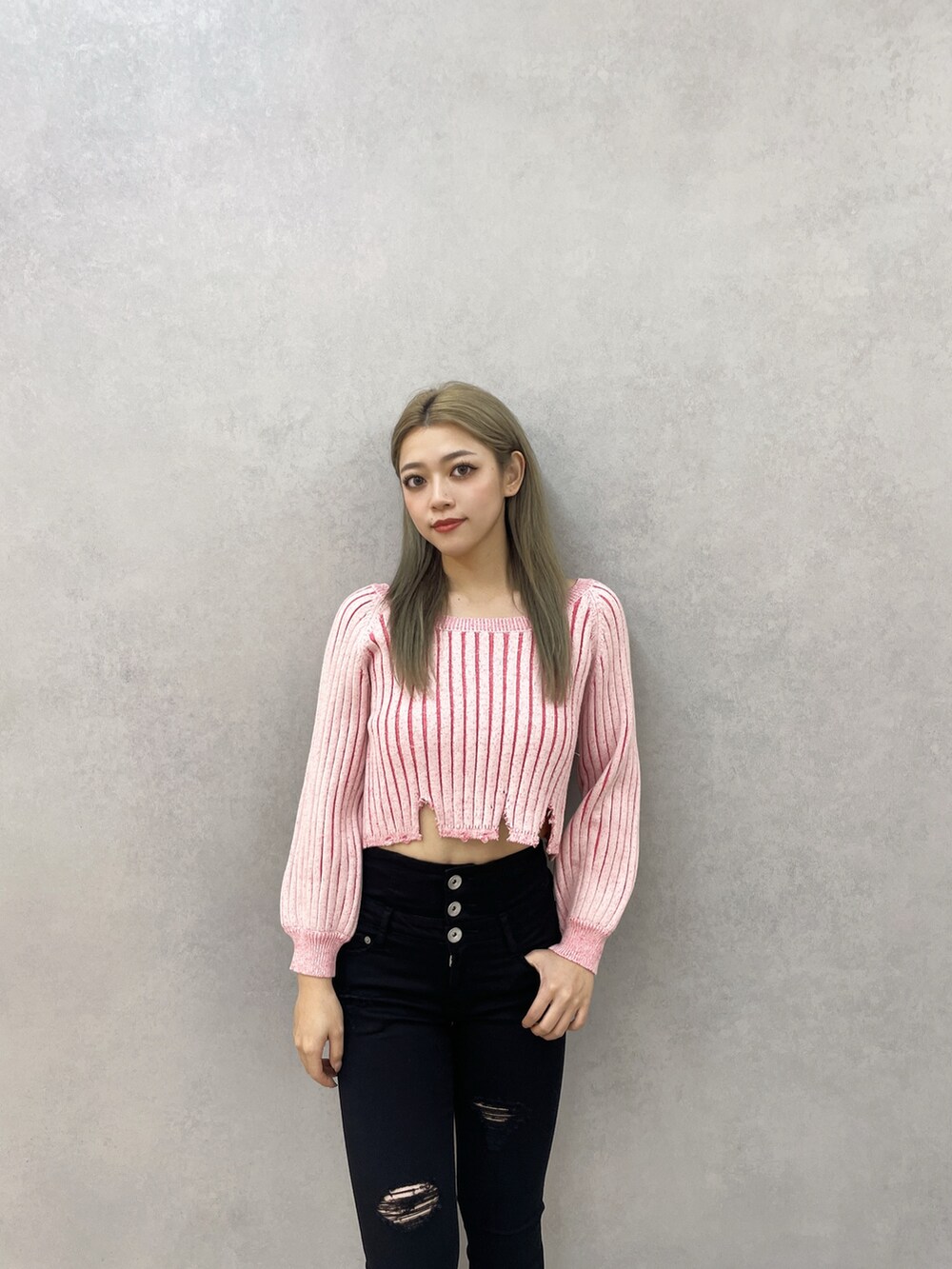 ピンク系のニット/セーター、ブラック系のデニムパンツ、ブラック系のパンプスを着用したレディースの冬コーディネートの3枚目の写真