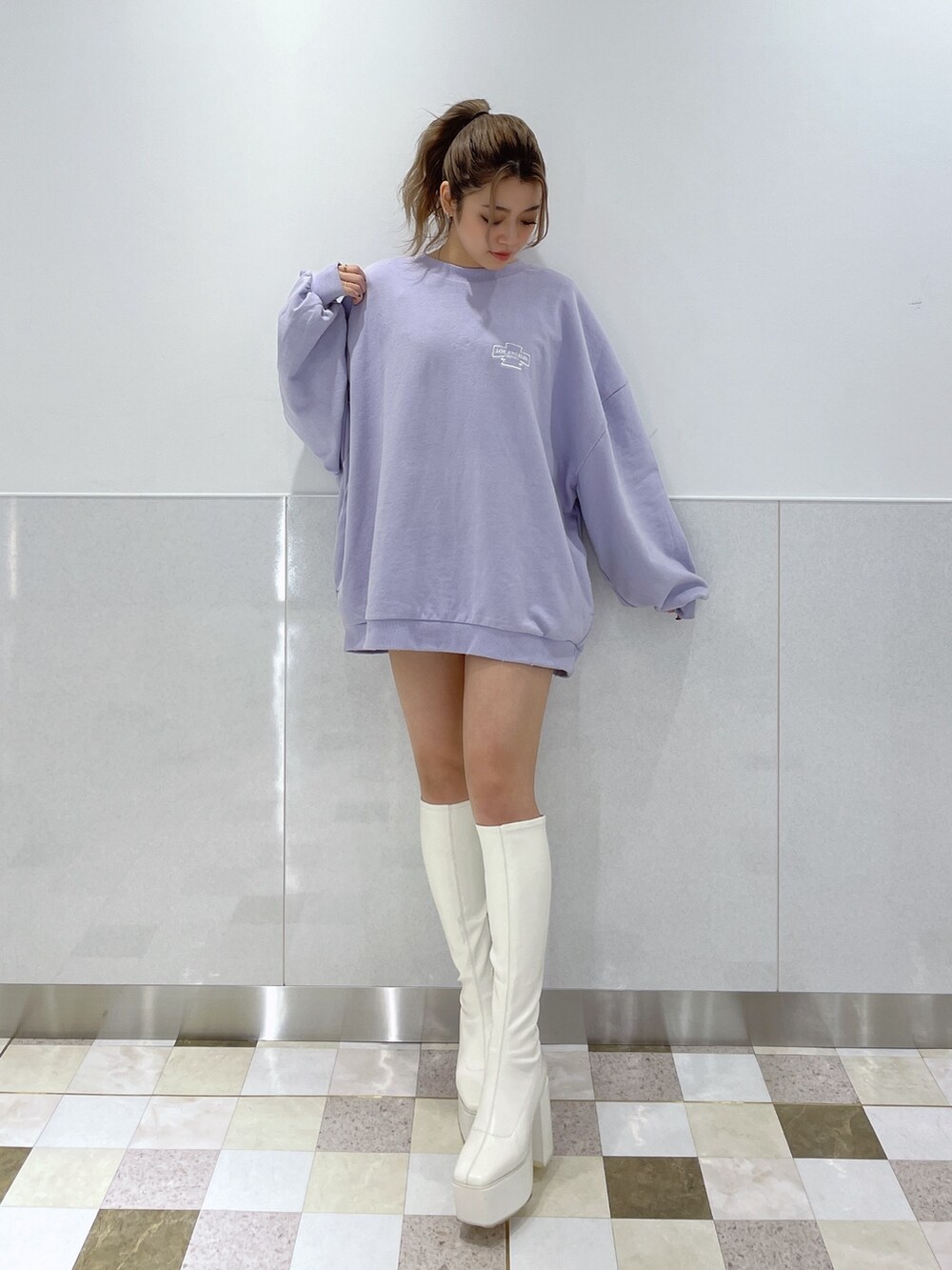 パープル系のスウェット、ホワイト系のブーツを着用したレディースの冬コーディネートの3枚目の写真