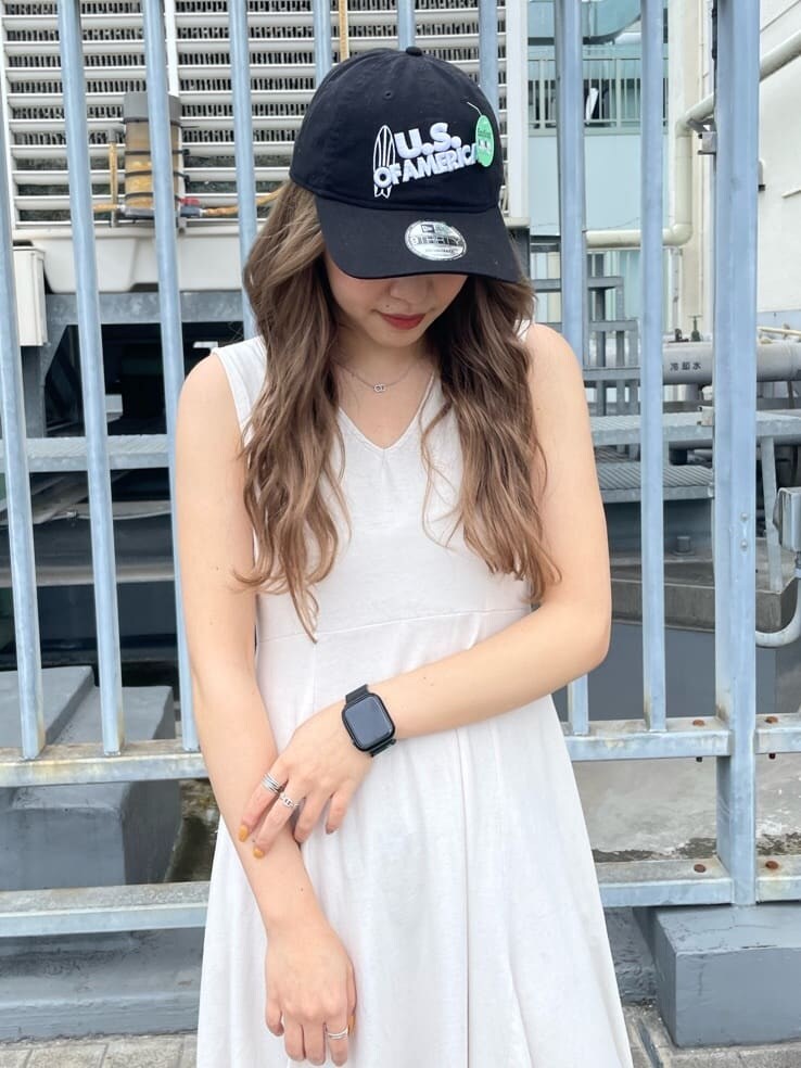 ホワイト系のワンピース、ブラック系のキャップを着用したレディースの春コーディネートの4枚目の写真