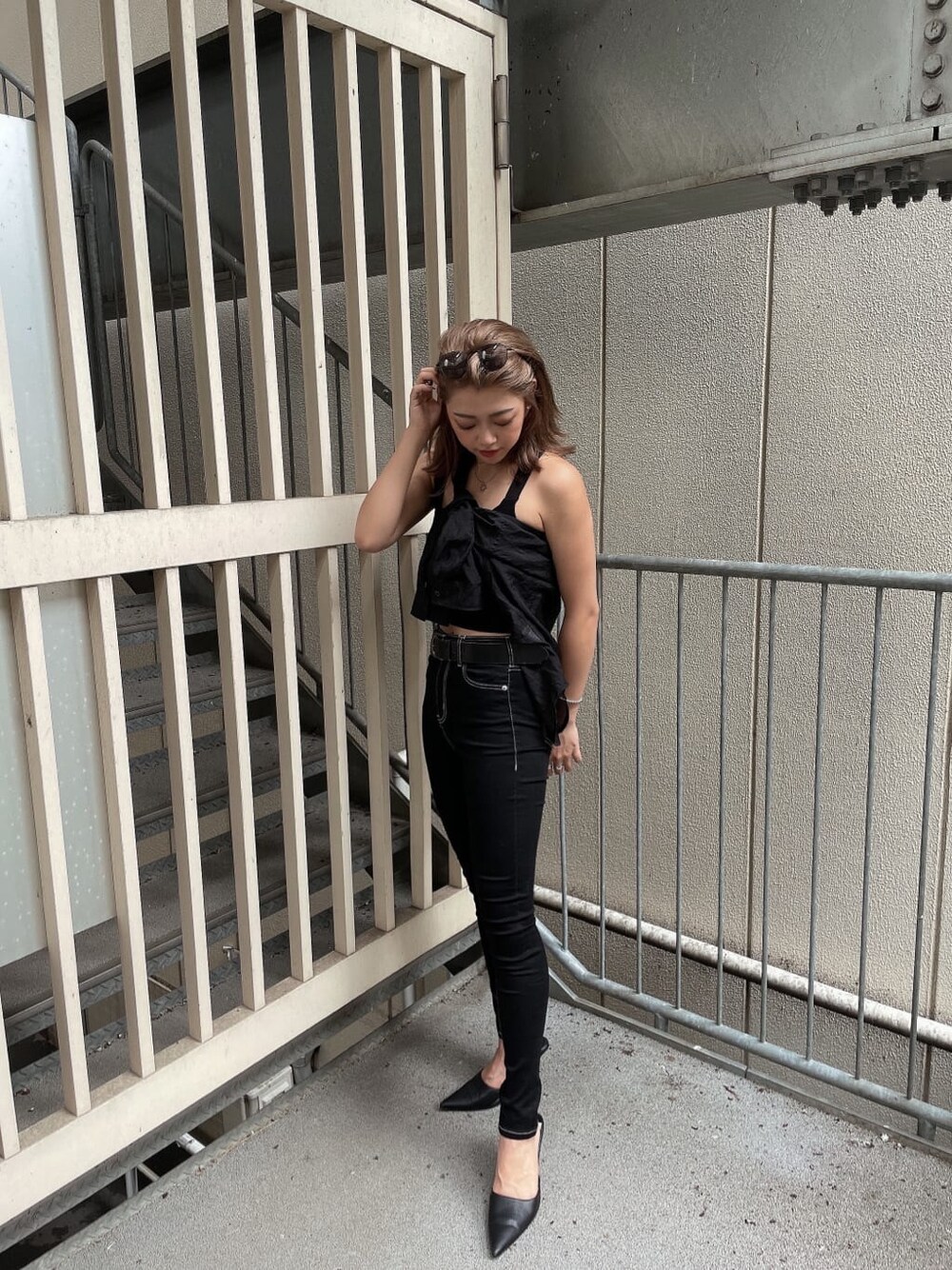 ブラック系のシャツ/ブラウス、ブラック系のパンプス、ブラック系のデニムパンツを着用したレディースの夏コーディネートの2枚目の写真