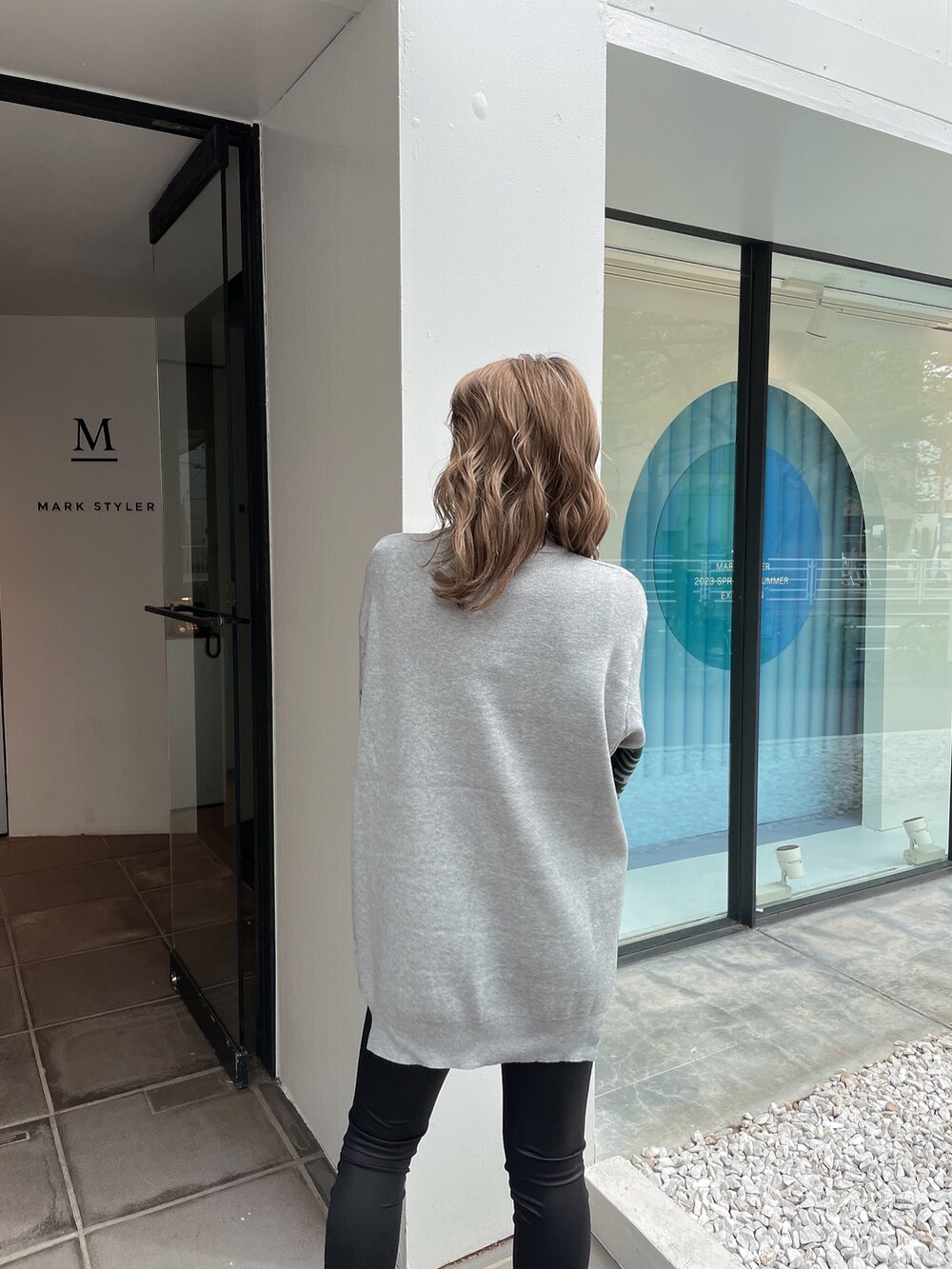 グレー系のニット/セーター、ブラック系のその他パンツ、ブラック系のパンプスを着用したレディースの春コーディネートの4枚目の写真