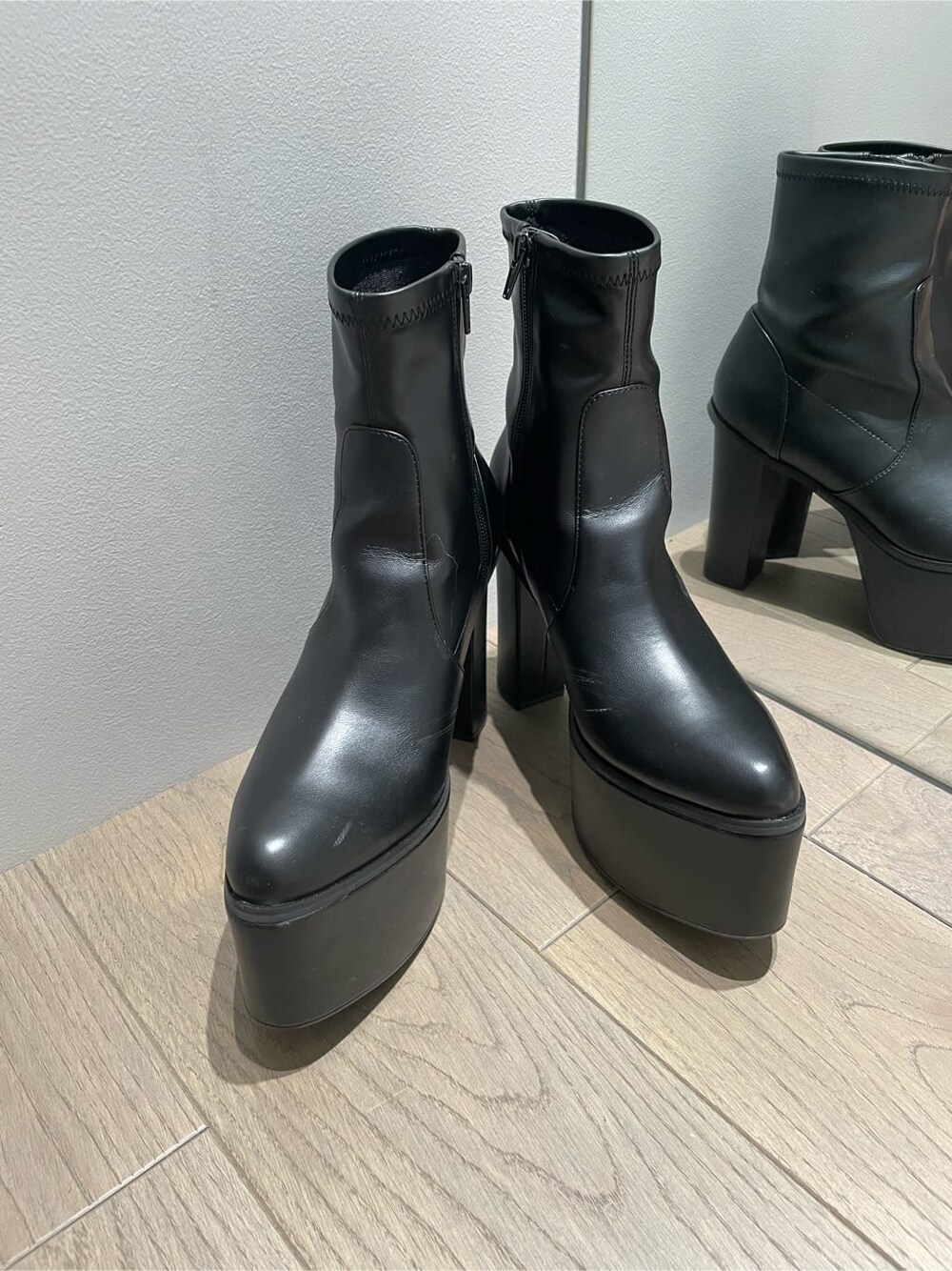 ブラック系のブーツ、ブラック系のデニムパンツ、ブラック系のベストを着用したレディースの秋コーディネートの7枚目の写真