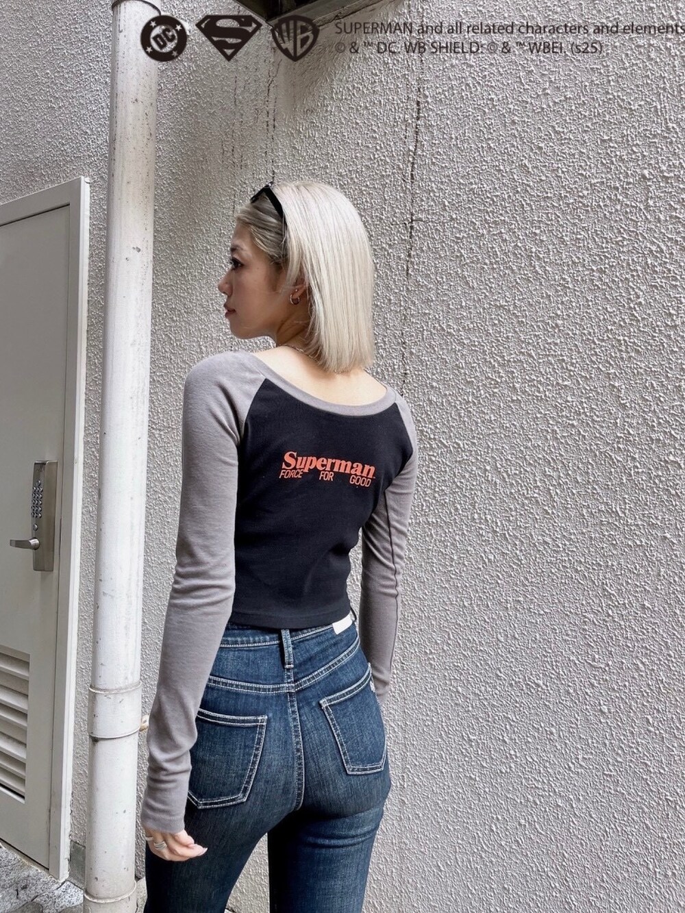 ブラック系のTシャツ/カットソー、ブルー系のデニムパンツ、ブラック系のブーツを着用したレディースの秋コーディネートの5枚目の写真