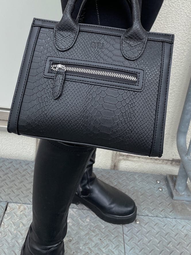 ブラック系のハンドバッグ、ブラック系のデニムパンツ、ホワイト系のシャツ/ブラウスを着用したレディースの秋コーディネートの6枚目の写真