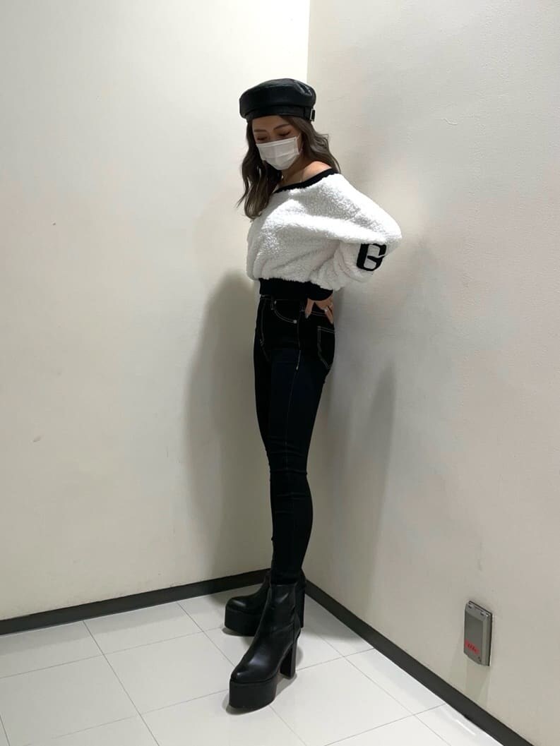 ブラック系のデニムパンツ、ブラック系のブーツ、ホワイト系のTシャツ/カットソーを着用したレディースの秋コーディネートの2枚目の写真