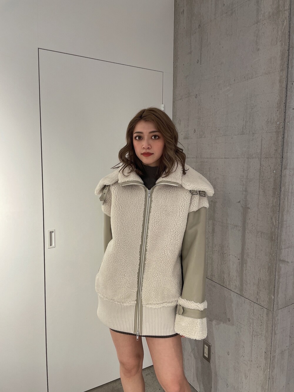 ベージュ系のブルゾン、ブラック系のブーツを着用したレディースの冬コーディネートの3枚目の写真