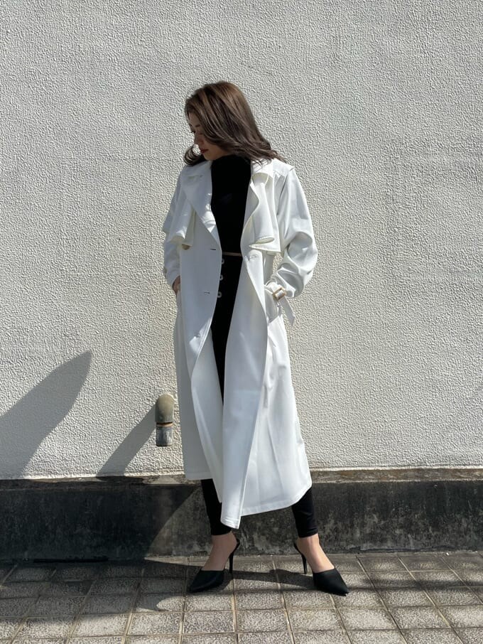 ブラック系のパンプス、ホワイト系のトレンチコートを着用したレディースの春コーディネートの4枚目の写真