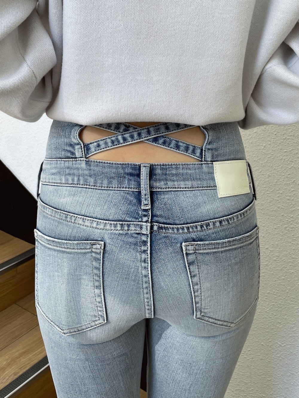 ベージュ系のニット/セーター、ブルー系のデニムパンツ、ホワイト系のパンプスを着用したレディースの冬コーディネートの6枚目の写真