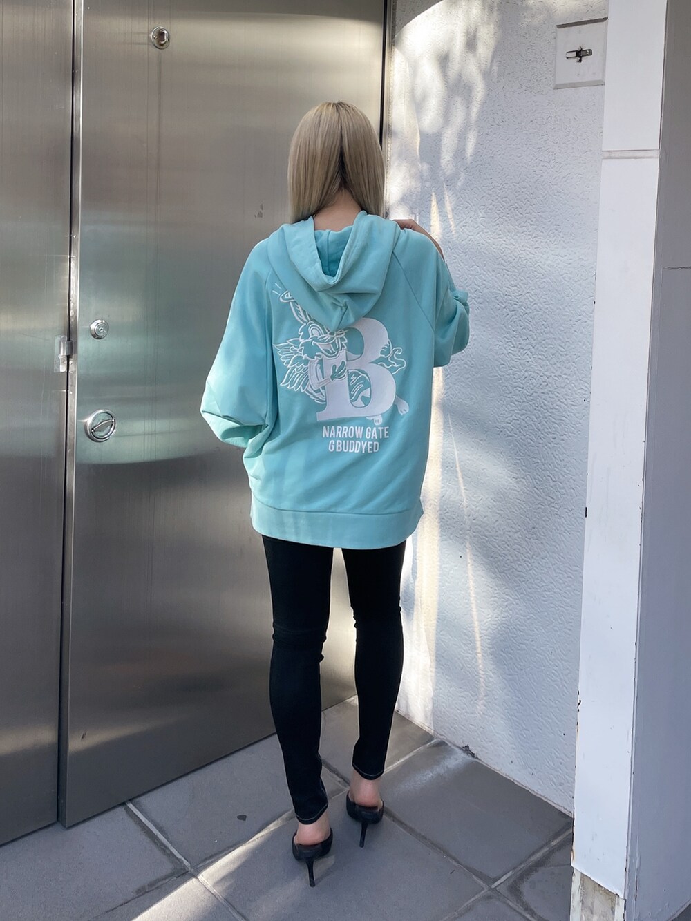 ブルー系のパーカー、ブラック系のデニムパンツを着用したレディースの冬コーディネートの3枚目の写真