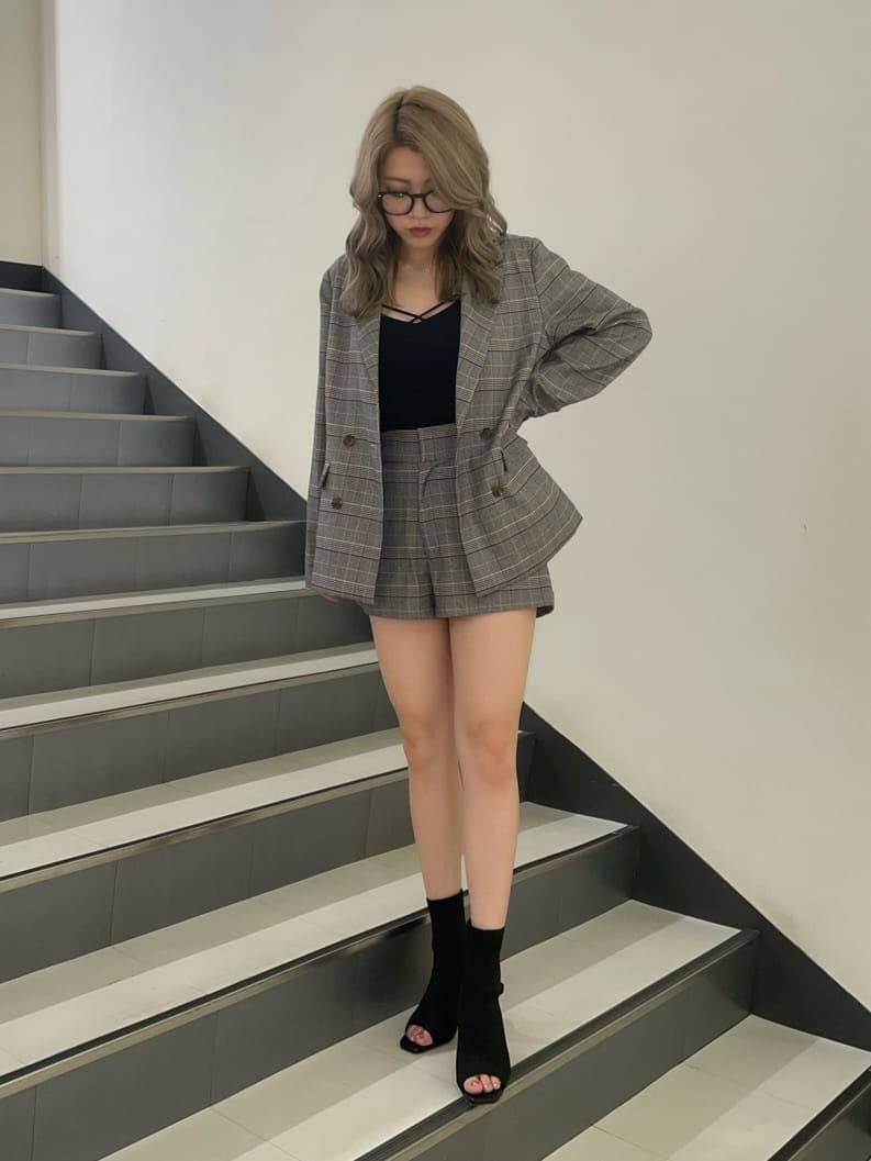 ブラック系のブーツ、ブラック系のキャミソール、ベージュ系のテーラードジャケットを着用したレディースの夏コーディネートの3枚目の写真