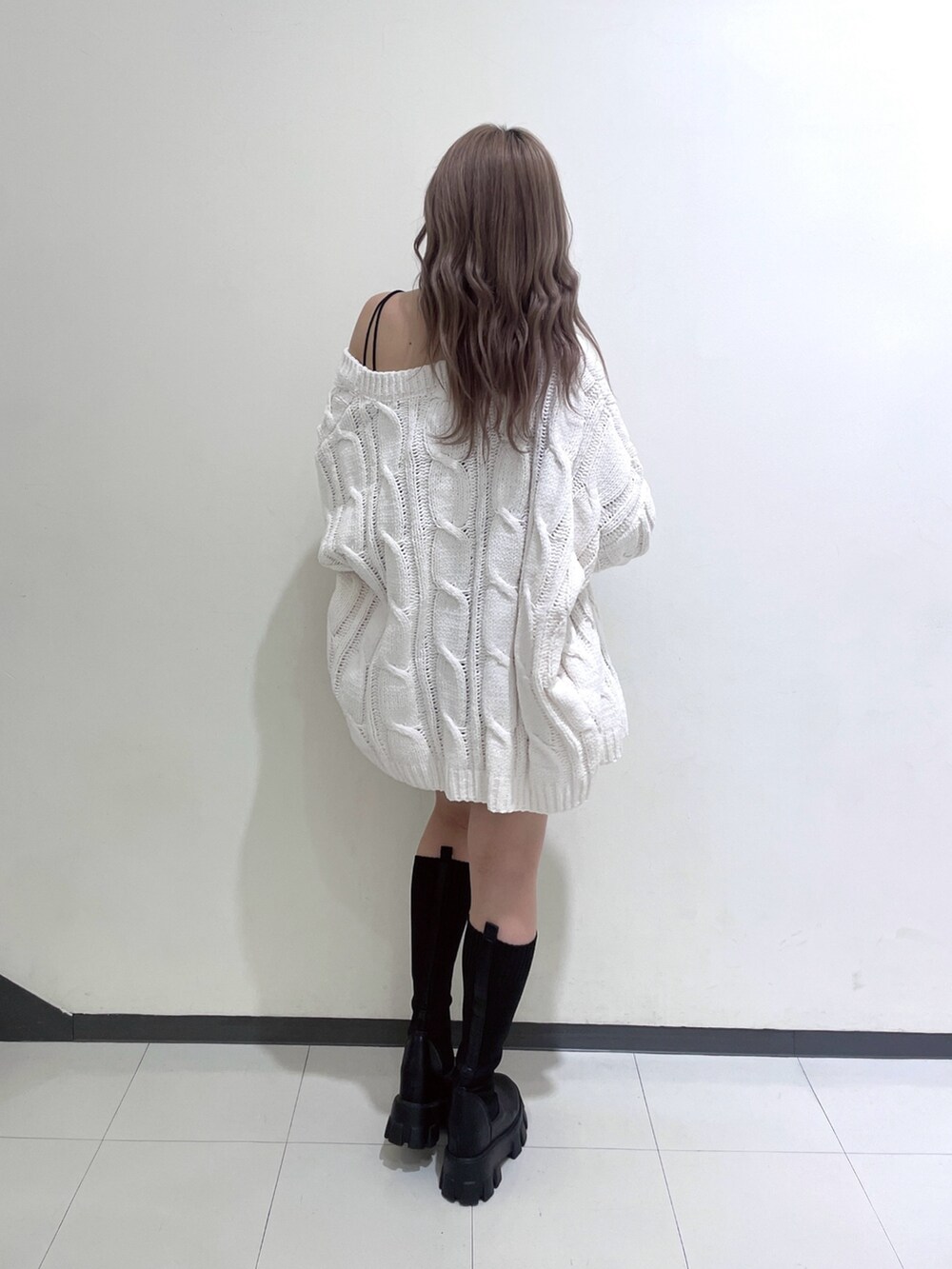 ホワイト系のカーディガン/ボレロ、ブラック系のデニムスカート、ブラック系のブーツを着用したレディースの冬コーディネートの3枚目の写真