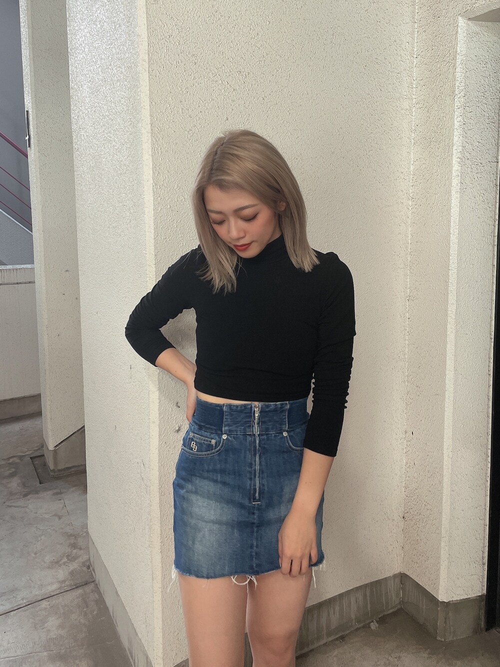 ブラック系のブルゾン、ブルー系のデニムスカート、ブラック系のスニーカーを着用したレディースの秋コーディネートの5枚目の写真