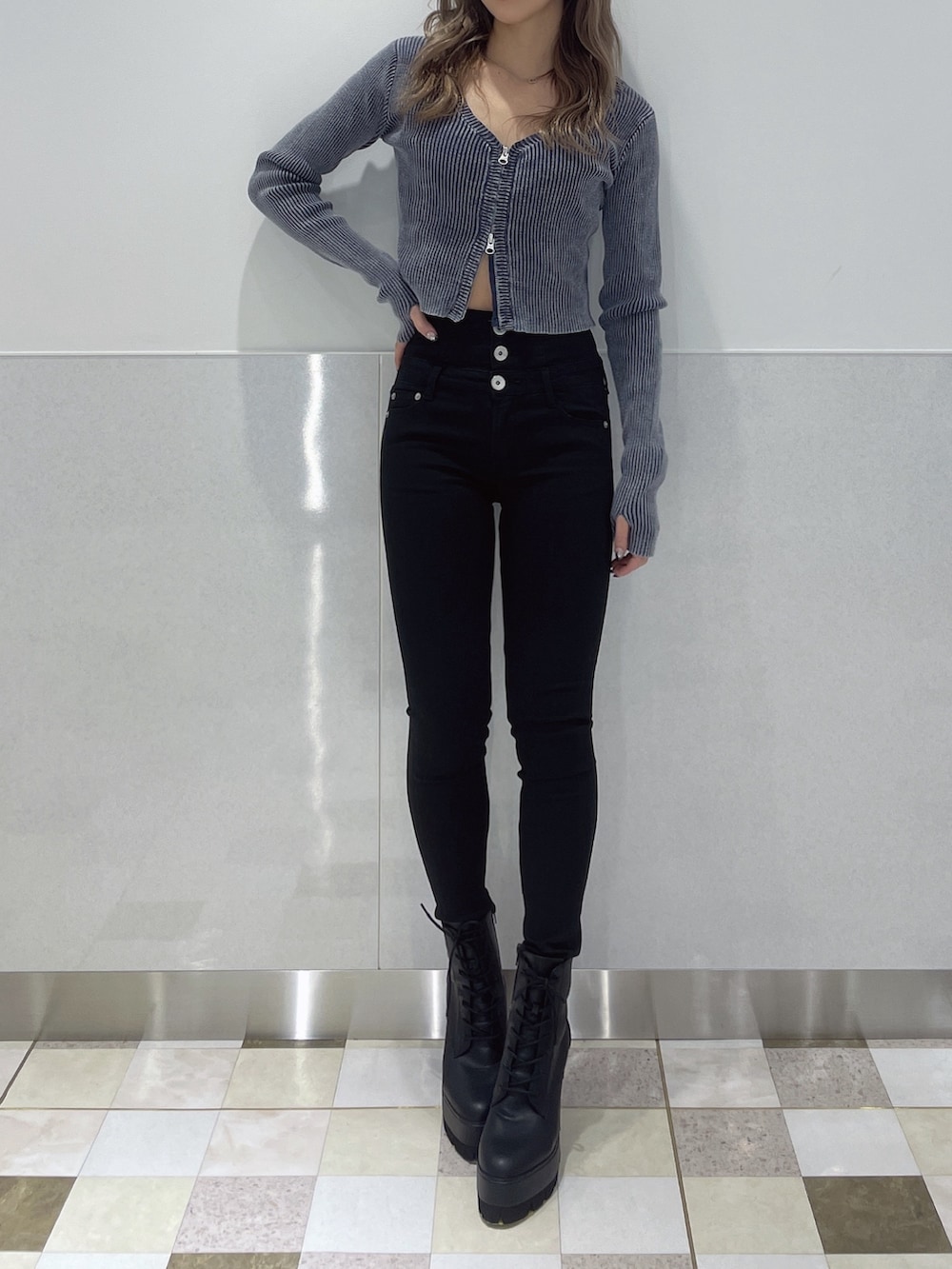 ブルー系のニット/セーター、ブラック系のデニムパンツ、ブラック系のブーツを着用したレディースの冬コーディネートの4枚目の写真