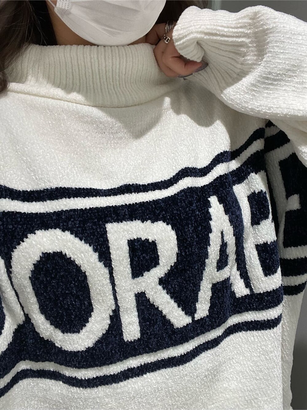 ホワイト系のニット/セーター、ホワイト系のパンプス、ブルー系のデニムパンツを着用したレディースの秋コーディネートの5枚目の写真