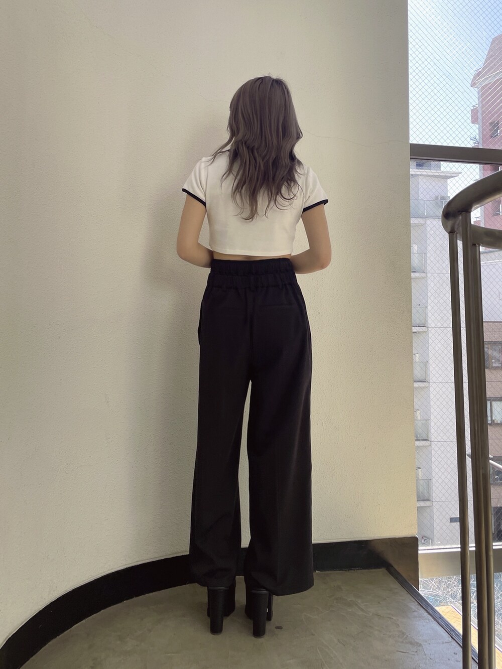 ブラック系のその他パンツ、ブラック系のサンダル、ホワイト系のTシャツ/カットソーを着用したレディースの春コーディネートの3枚目の写真