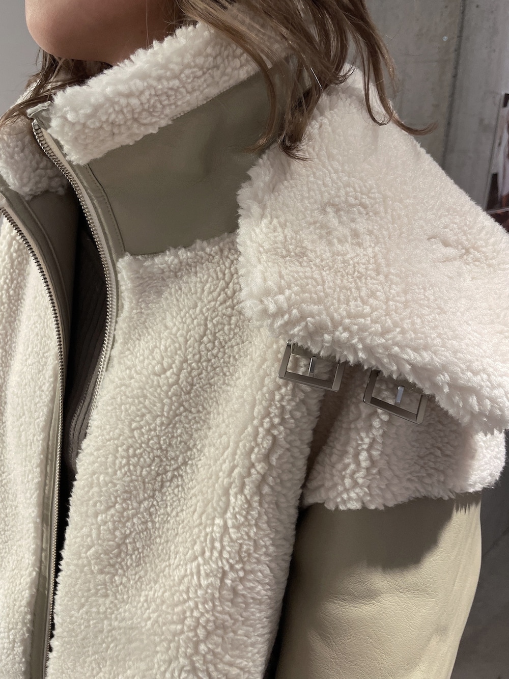 ベージュ系のブルゾン、ブラック系のブーツを着用したレディースの冬コーディネートの5枚目の写真