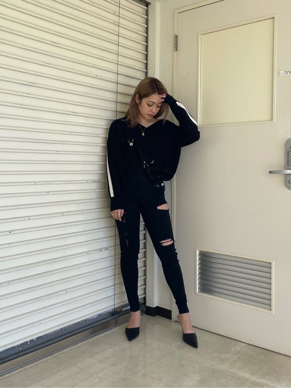 ブラック系のパンプス、ブラック系のニット/セーター、ブラック系のサロペット/オーバーオールを着用したレディースの冬コーディネートの3枚目の写真