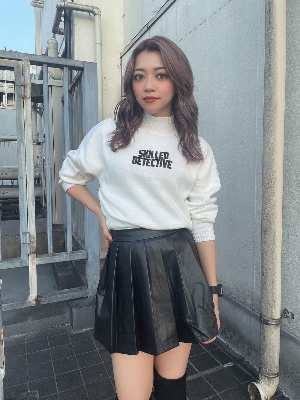 ホワイト系のニット/セーター、ブラック系のスカート、ブラック系のブーツを着用したレディースの秋コーディネートの4枚目の写真