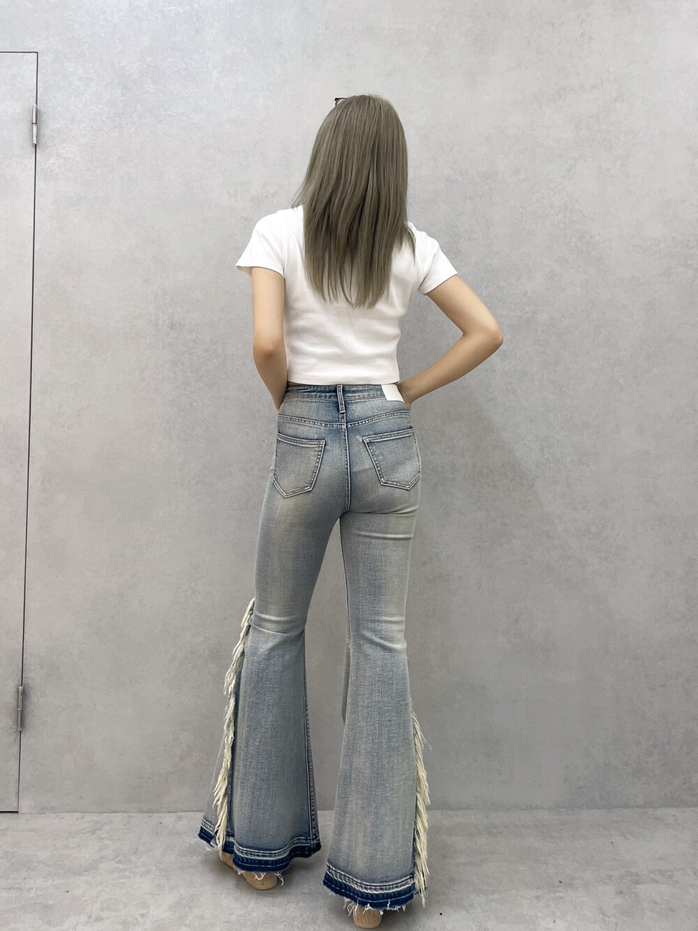 ホワイト系のTシャツ/カットソー、ブルー系のデニムパンツ、ホワイト系のサンダルを着用したレディースの春コーディネートの4枚目の写真