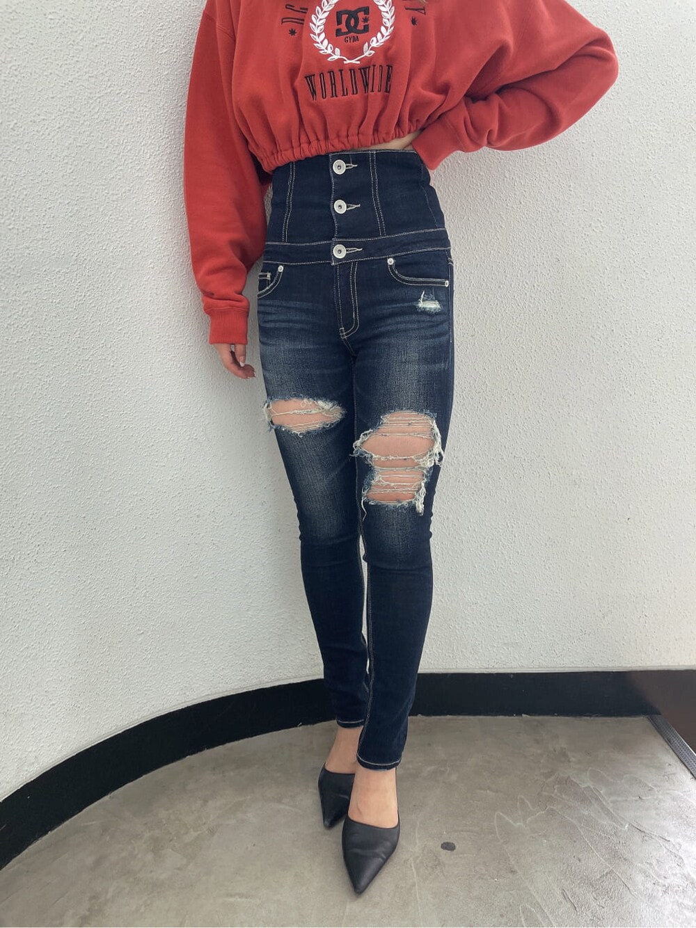 ブラック系のパンプス、ブルー系のデニムパンツ、オレンジ系のスウェットを着用したレディースの夏コーディネートの7枚目の写真