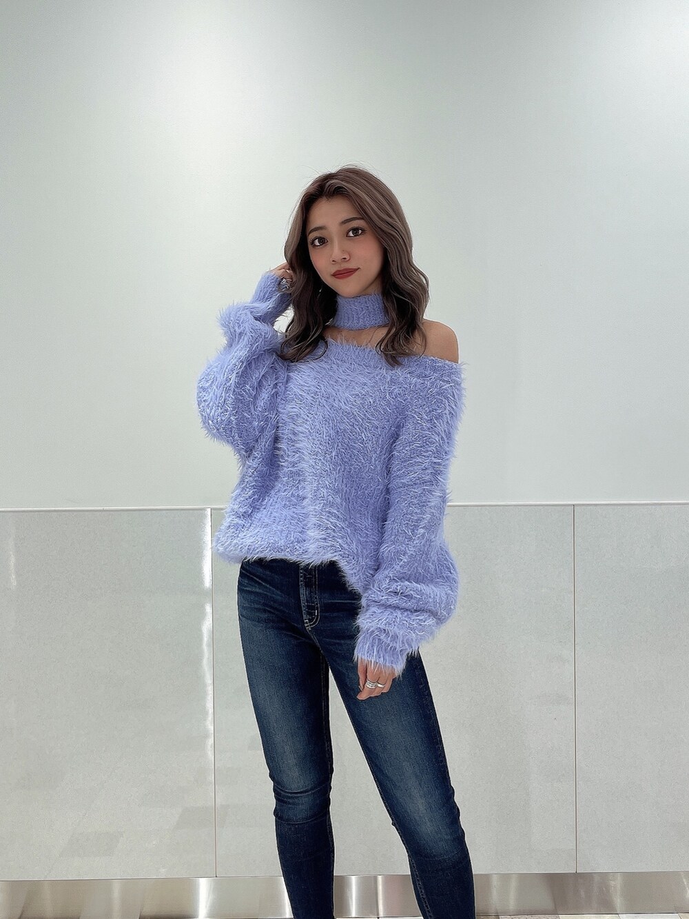 パープル系のニット/セーター、ブルー系のデニムパンツ、ブラック系のブーツを着用したレディースの秋コーディネートの4枚目の写真