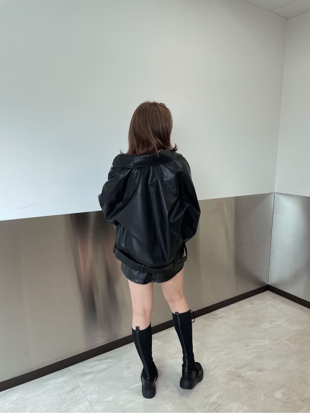 ブラック系のブーツ、ブラック系のTシャツ/カットソー、ブラック系のライダースジャケットを着用したレディースの秋コーディネートの2枚目の写真