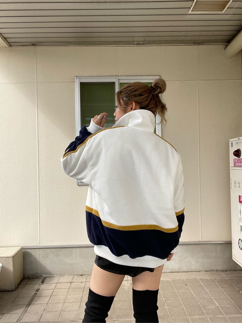 ホワイト系のブルゾン、ブラック系のブーツを着用したレディースの秋コーディネートの4枚目の写真