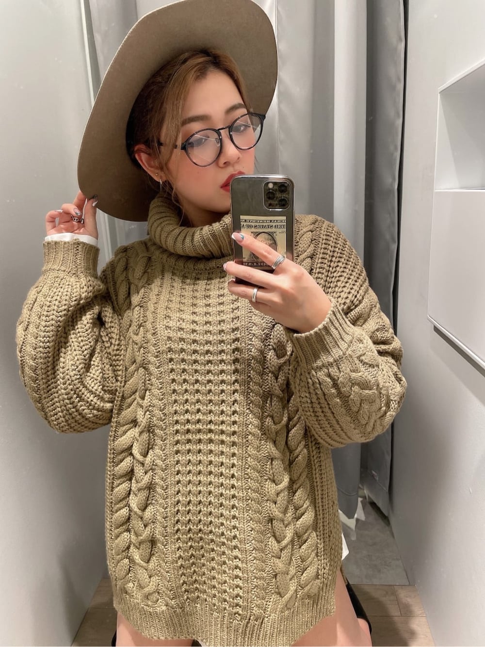 ブラック系のブーツ、ブラック系のデニムパンツ、ベージュ系のニット/セーターを着用したレディースの秋コーディネートの2枚目の写真