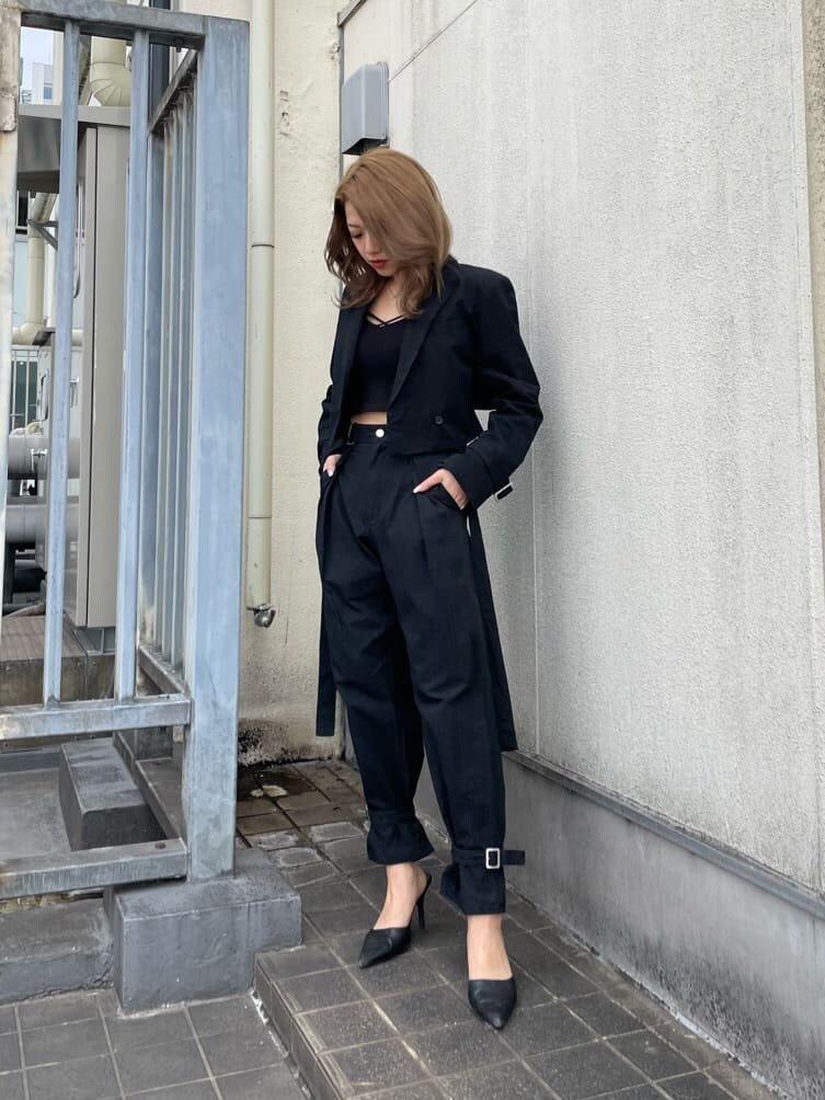 ブラック系のパンプス、ブラック系のスラックス、ブラック系のキャミソールを着用したレディースの春コーディネートの2枚目の写真