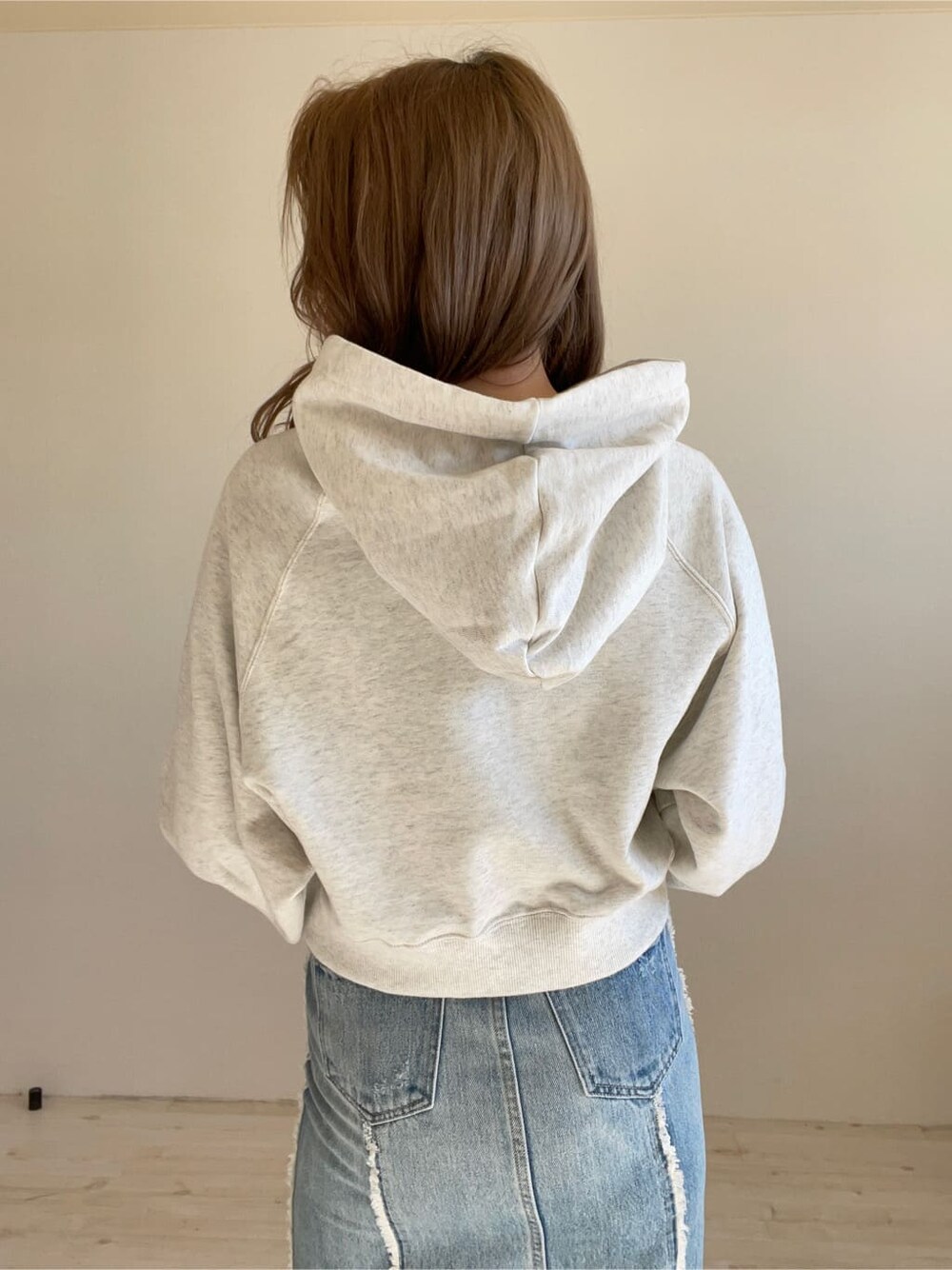 ブラック系のブーツ、グレー系のパーカー、ブルー系のデニムスカートを着用したレディースの冬コーディネートの5枚目の写真