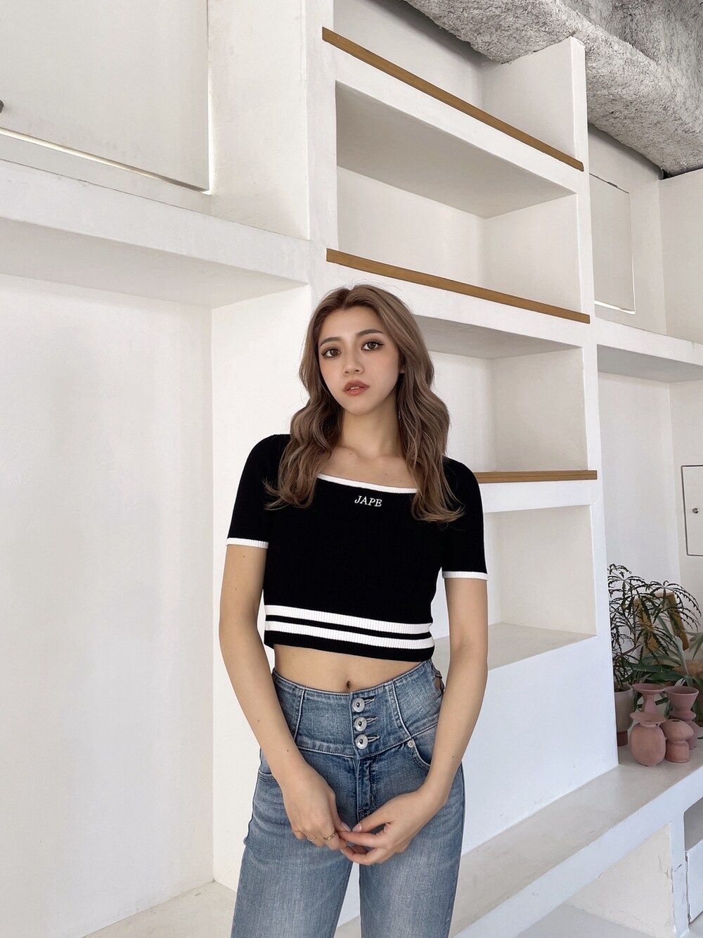 ブラック系のサンダル、ブルー系のデニムパンツ、ブラック系のニット/セーターを着用したレディースの春コーディネートの4枚目の写真