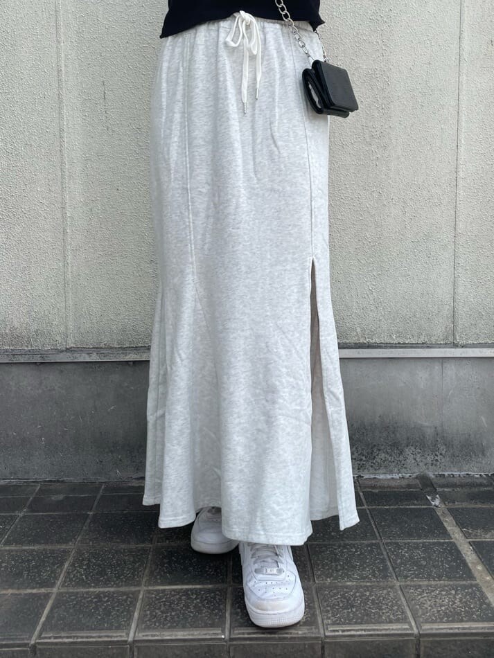 グレー系のスカート、ブラック系のTシャツ/カットソー、ブラック系の財布を着用したレディースの夏コーディネートの6枚目の写真