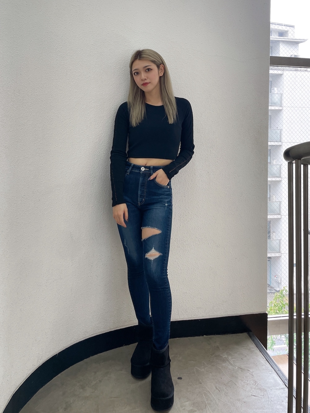 ブラック系のTシャツ/カットソー、ブルー系のデニムパンツ、ブラック系のブーツを着用したレディースの秋コーディネートの2枚目の写真