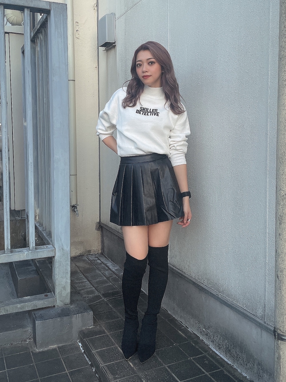 ホワイト系のニット/セーター、ブラック系のスカート、ブラック系のブーツを着用したレディースの秋コーディネートの2枚目の写真