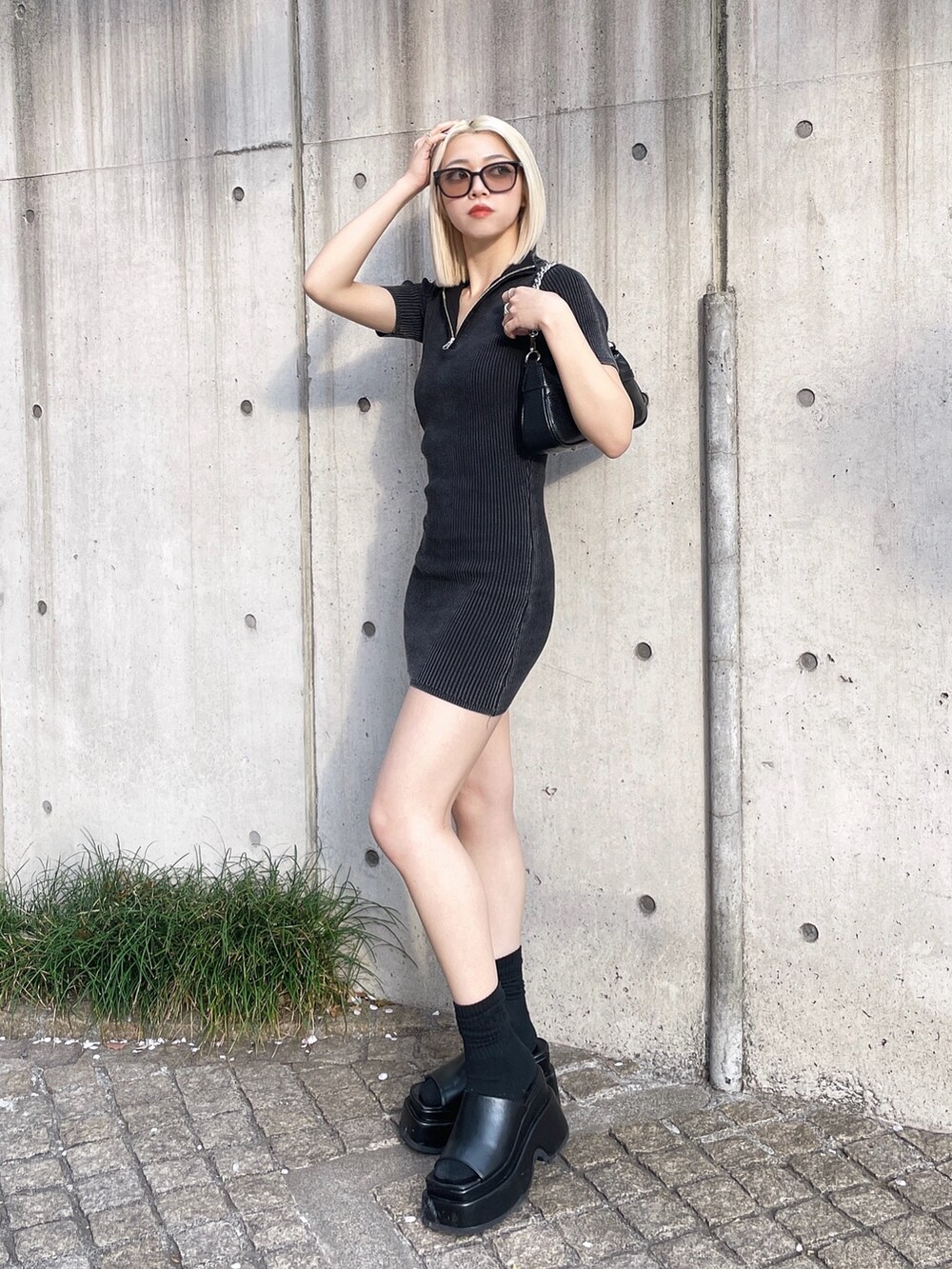 ブラック系のワンピース、ブラック系のサンダル、ブラック系のハンドバッグを着用したレディースの春コーディネートの3枚目の写真