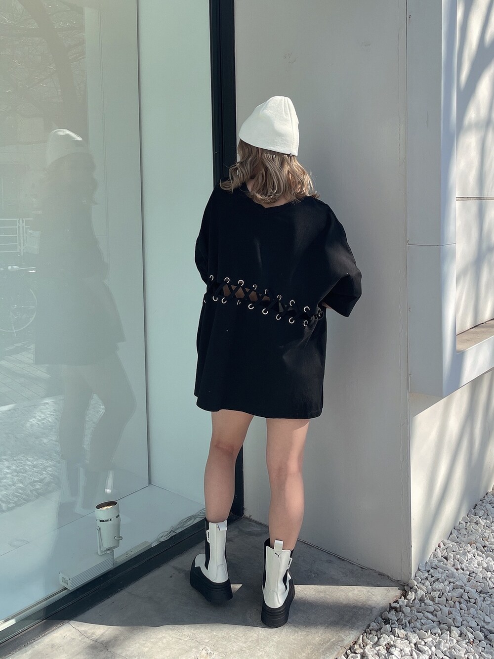 ブラック系のTシャツ/カットソー、ホワイト系のブーツ、ホワイト系のニットキャップ/ビーニーを着用したレディースの冬コーディネートの3枚目の写真