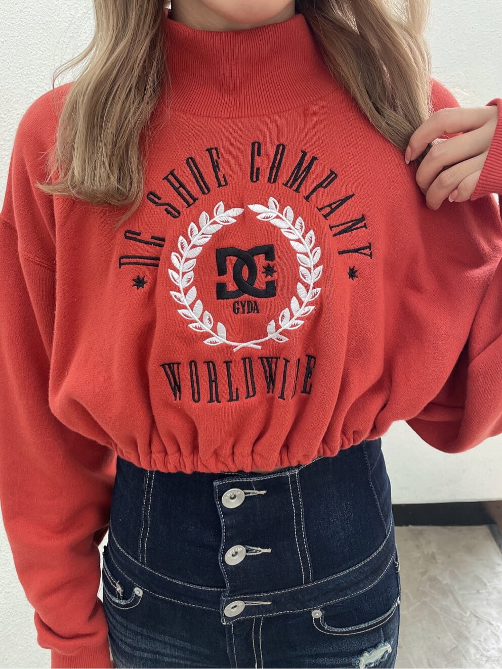 ブラック系のパンプス、ブルー系のデニムパンツ、オレンジ系のスウェットを着用したレディースの夏コーディネートの6枚目の写真