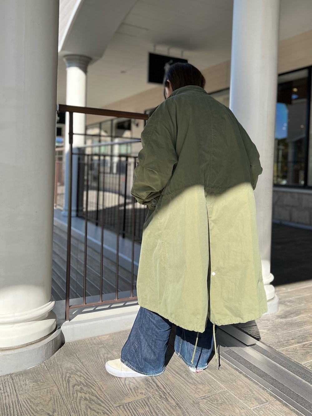 グリーン系のモッズコートを着用したレディースの秋コーディネートの3枚目の写真