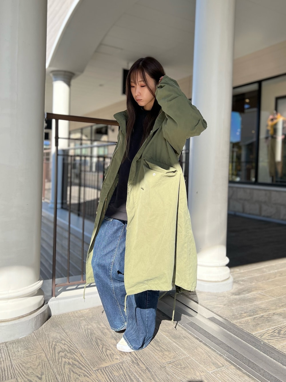 グリーン系のモッズコートを着用したレディースの秋コーディネートの2枚目の写真