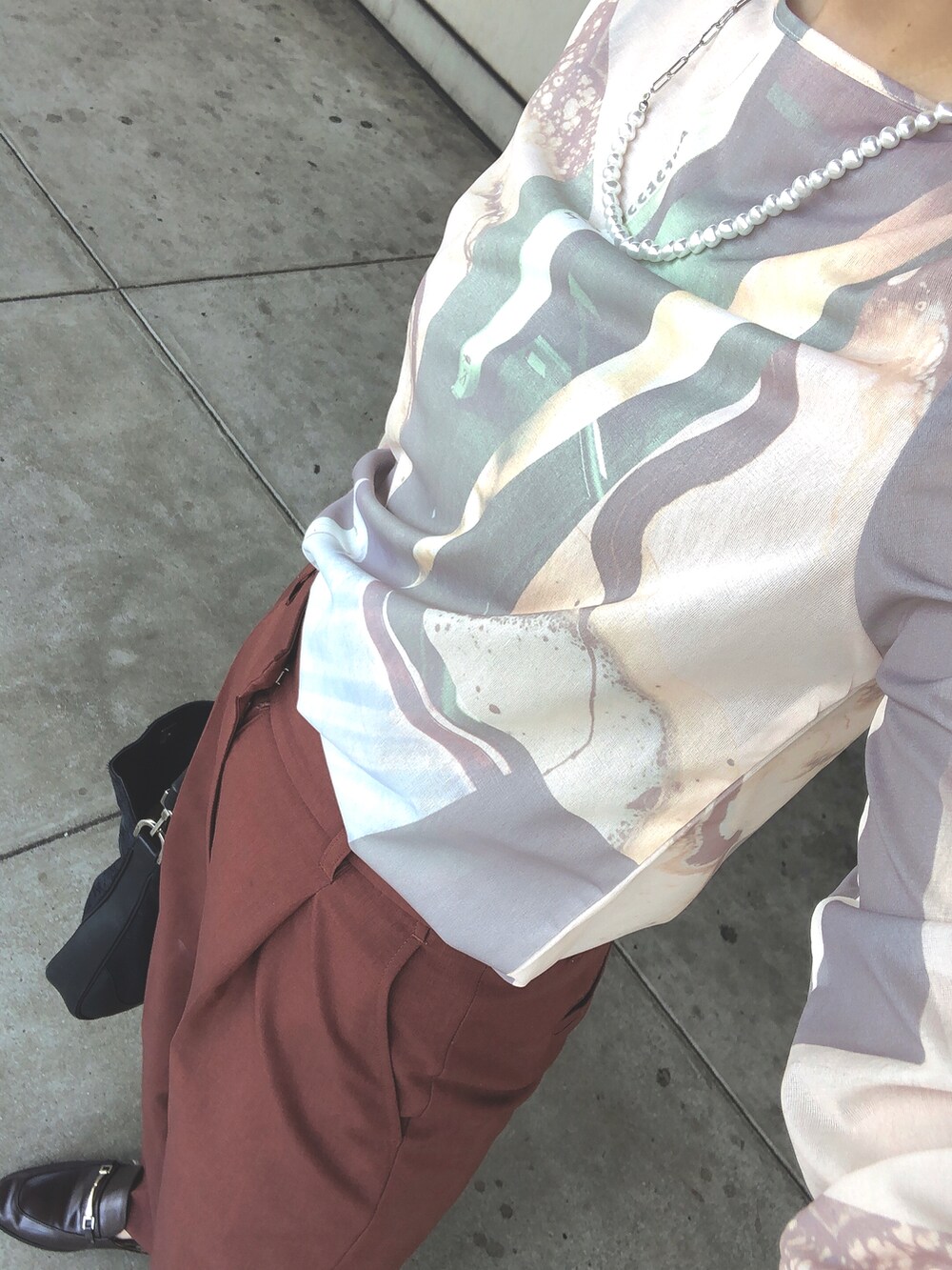 ホワイト系のTシャツ/カットソー、ブラウン系のスラックスを着用したレディースの秋コーディネートの2枚目の写真