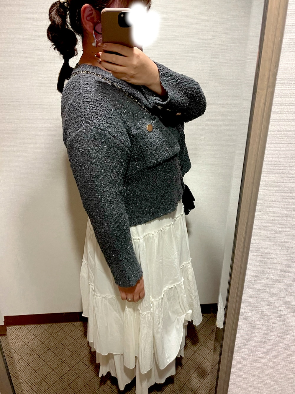 グレー系のカーディガン/ボレロ、ホワイト系のスカート、ブラック系のローファーを着用したレディースの秋コーディネートの2枚目の写真