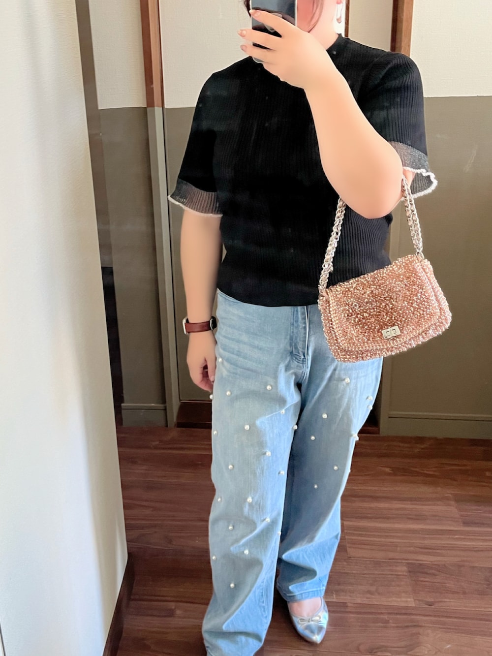 ブルー系のデニムパンツ、シルバー系のパンプス、ピンク系のショルダーバッグを着用したレディースの夏コーディネートの2枚目の写真