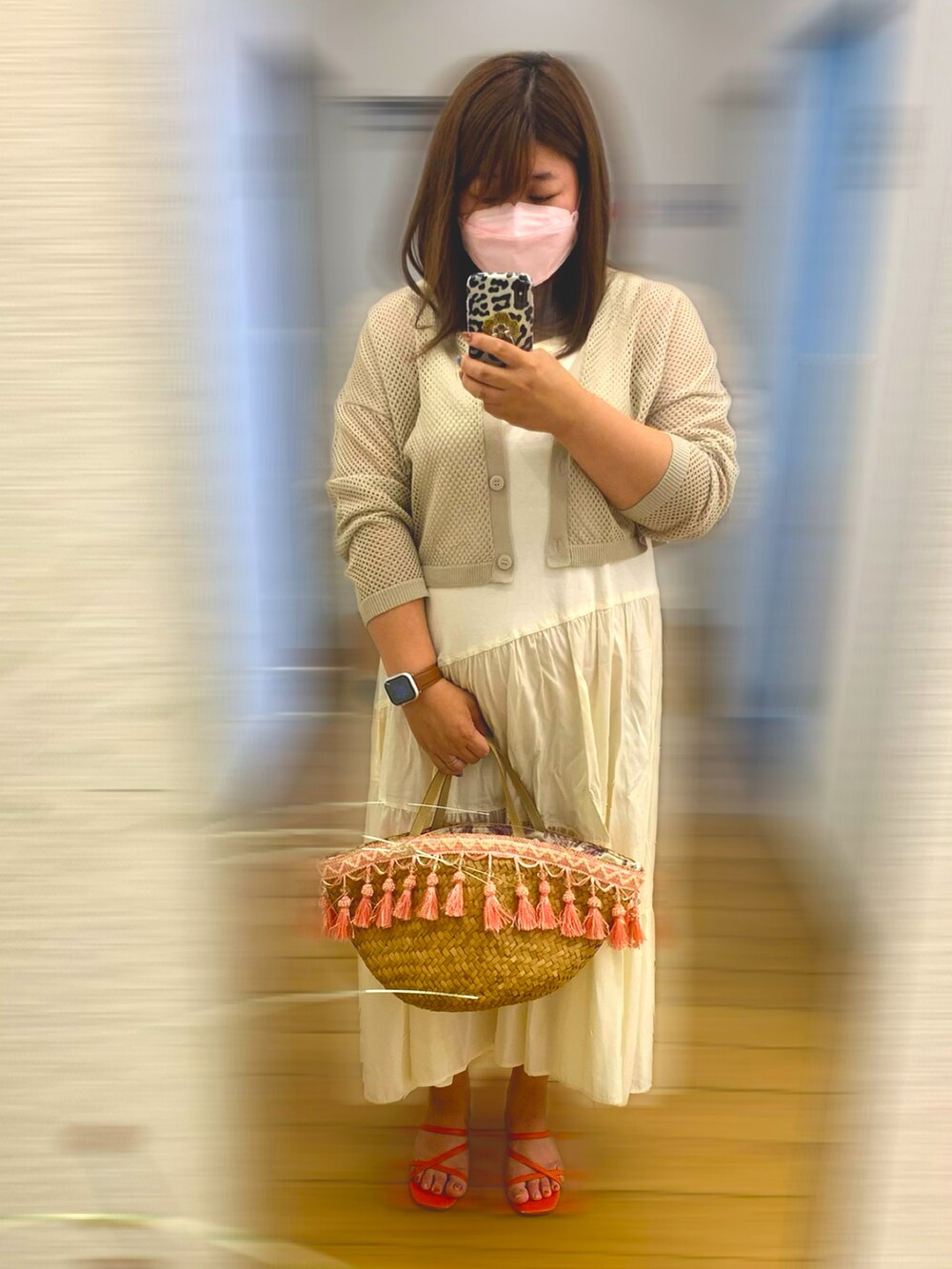 オレンジ系のサンダル、ベージュ系のワンピース、ベージュ系のかごバッグを着用したレディースの夏コーディネートの2枚目の写真