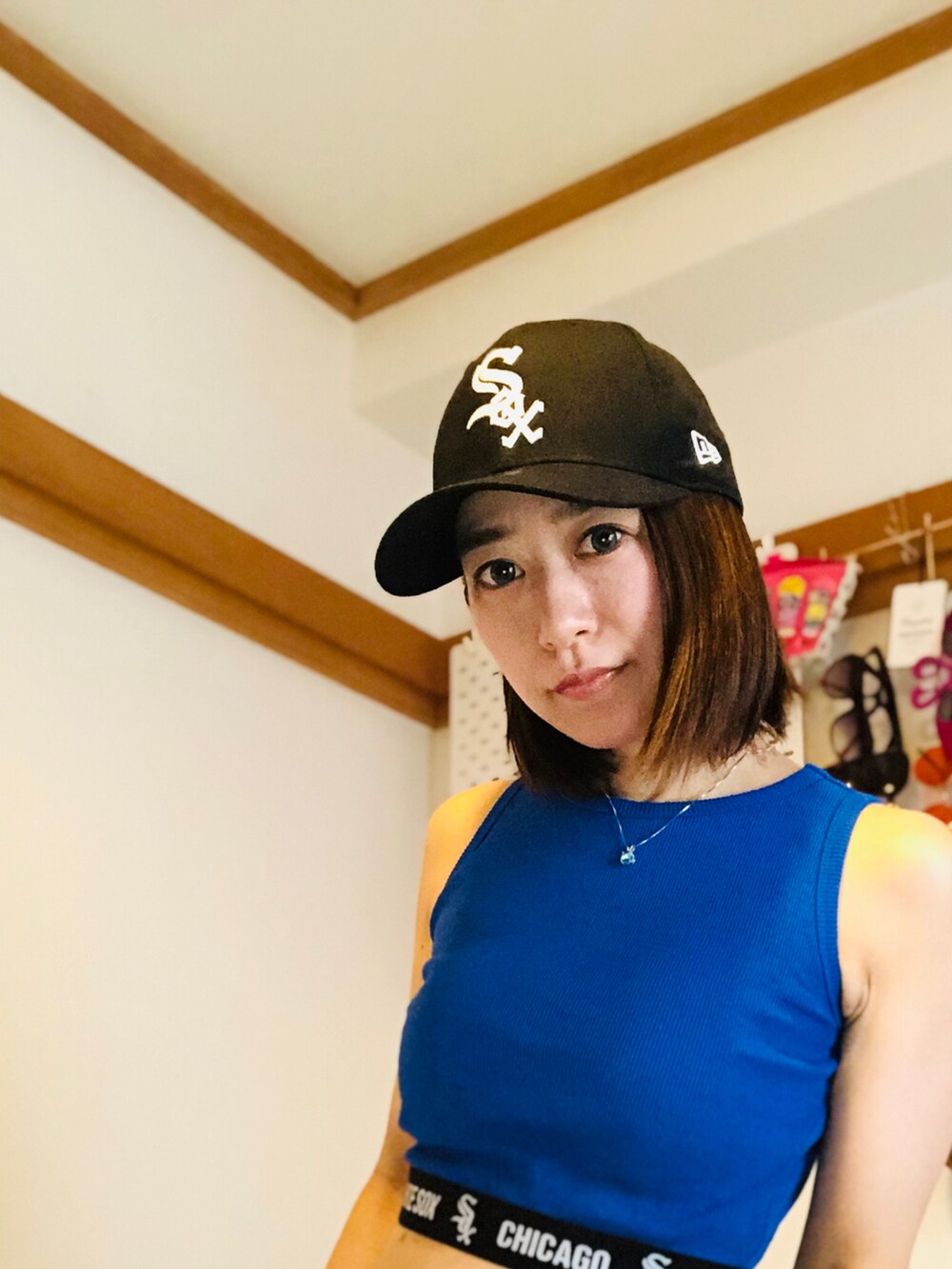 ブルー系のタンクトップ、ブラック系のキャップを着用したレディースの夏コーディネートの3枚目の写真