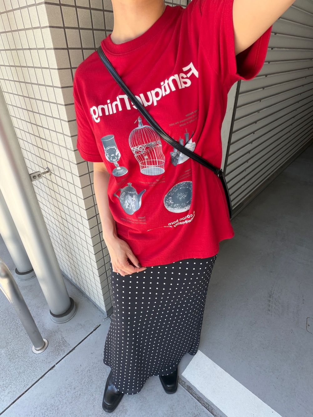 レッド系のTシャツ/カットソー、ブラック系のスカート、ブラック系のブーツを着用したレディースの夏コーディネートの4枚目の写真