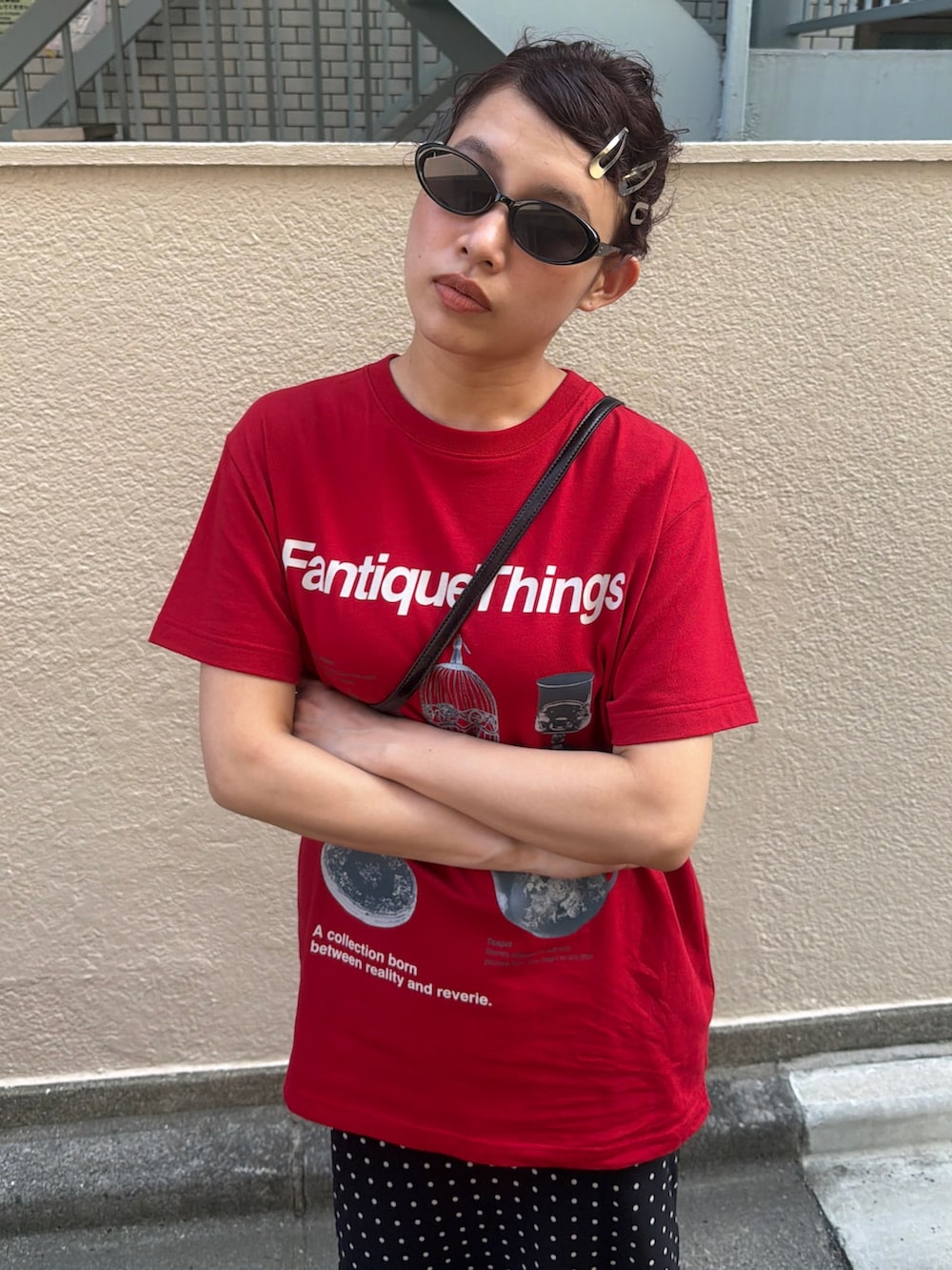 レッド系のTシャツ/カットソー、ブラック系のスカート、ブラック系のブーツを着用したレディースの夏コーディネートの3枚目の写真